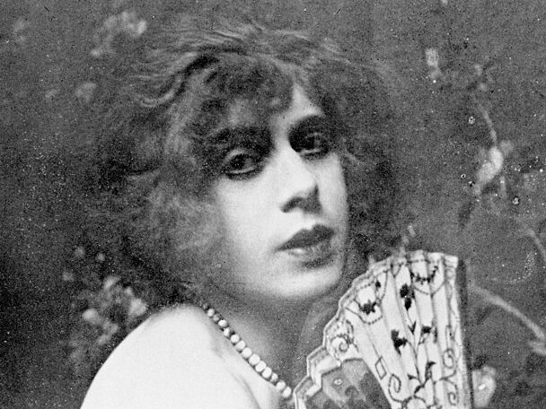 b/w antique photo of Lili Elbe holding a fan  