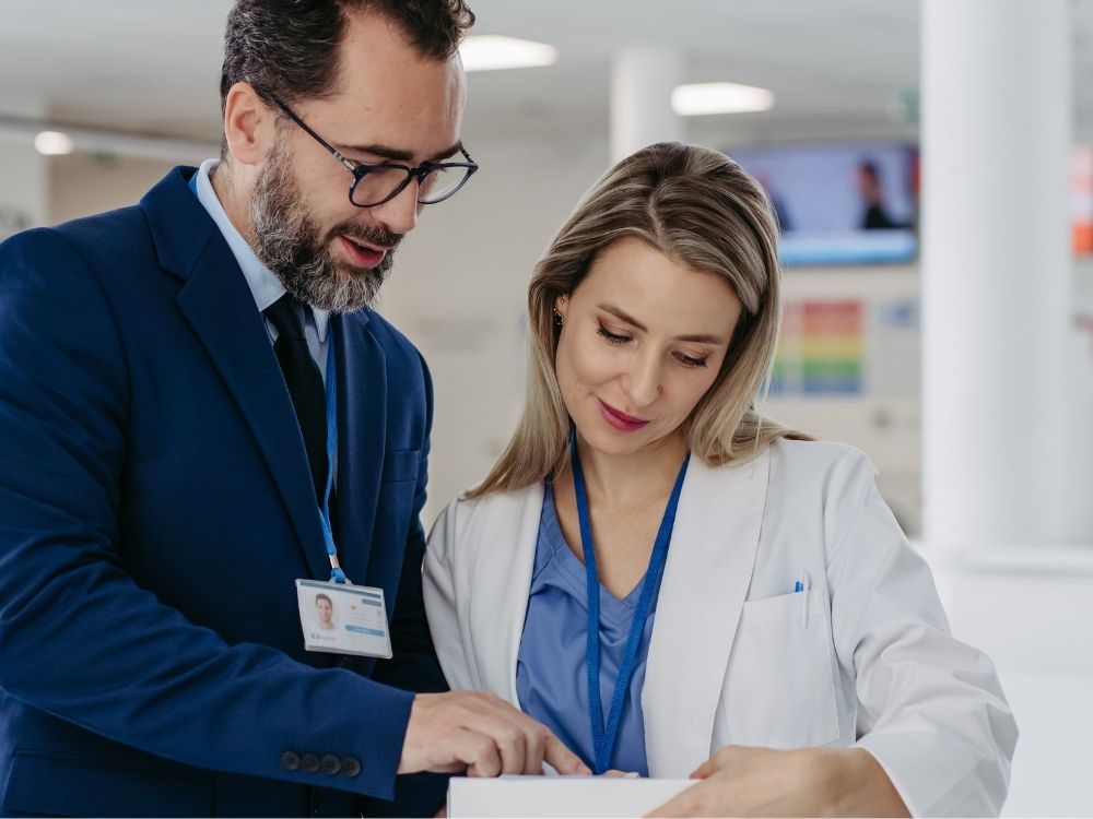 man in a suit talking to a doctor