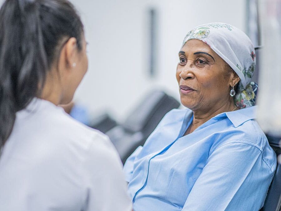Woman in oncology treatment talking to a provider